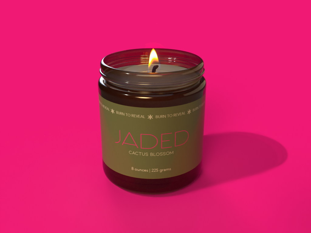 Cactus Blossom scented candle. The background is hot pink with an amber glass candle jar in the middle with a green label. The name of the candle is called Jaded.