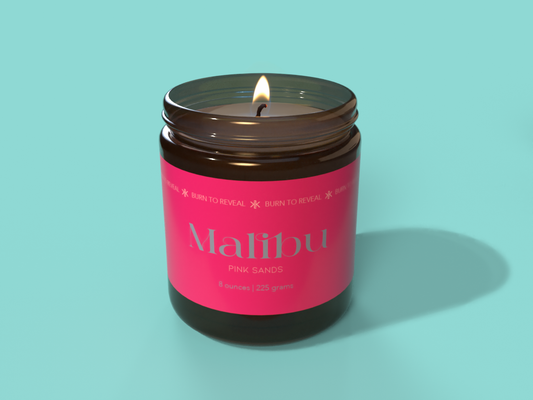 Malibu Barbie inspired candle. Blue background with the amber glass candle and a hot pink label.